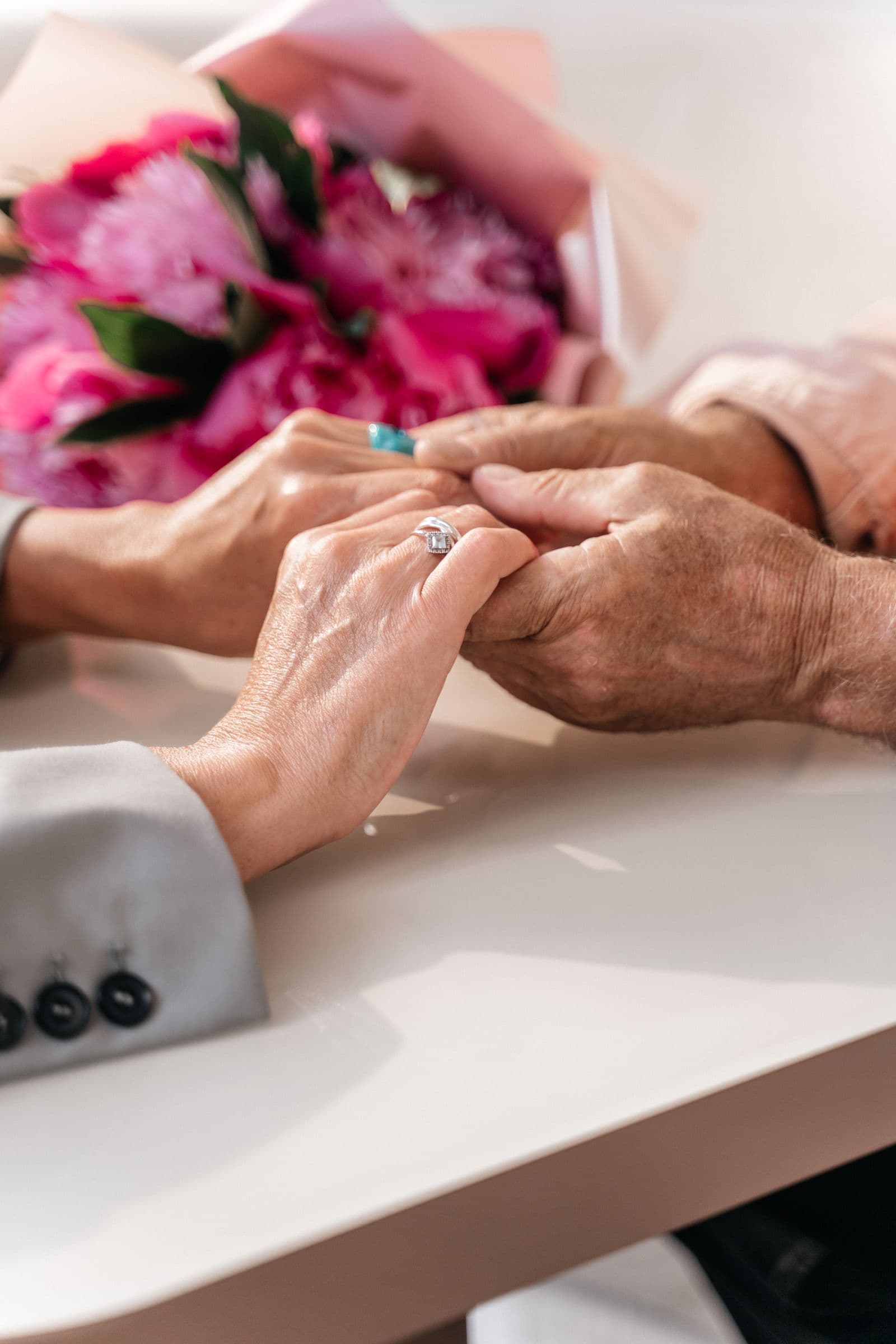Eine helfende Hand hält vertrauensvoll die Hand eines älteren Menschen